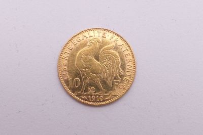 gros plan d'une pièce d'or sur une surface blanche
