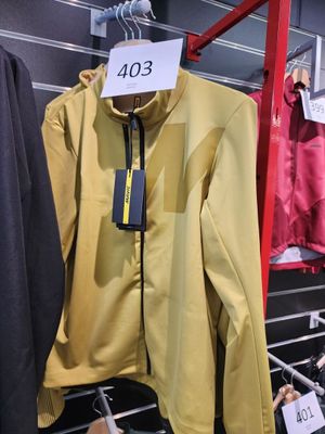 une veste jaune accrochée à un portant dans un magasin