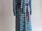 une robe bleue et blanche avec une ceinture rouge sur un mannequin