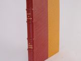 a red and yellow book sitting on a white surface
