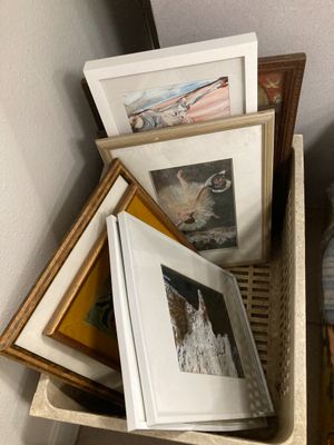 une pile de photos encadrées posées sur une étagère à côté d'un lit