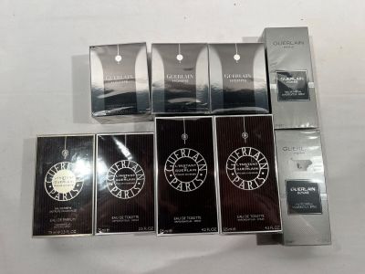plusieurs flacons de parfum de différents types posés sur une table blanche