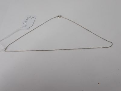 a silver necklace with a chain attached to it on a white surface