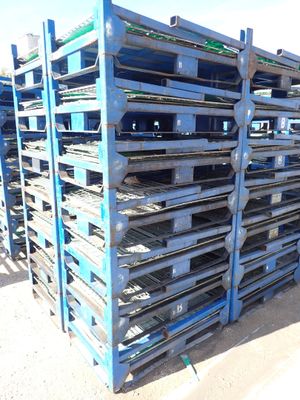 many pallets stacked on top of each other in the dirt