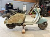 a scooter that is sitting on a stand in a garage