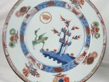 a blue and white plate with a bird and flowers on it