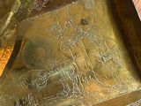un plateau en métal orné d'une image, posé sur une table en bois