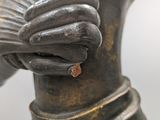 a close up of a statue of a person holding a fan