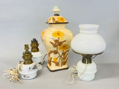 three vases and a lamp on a table