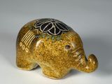 une figurine d'éléphant posée sur une surface blanche