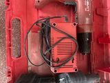 une image représentant une boîte à outils rouge contenant une perceuse filaire et d'autres outils