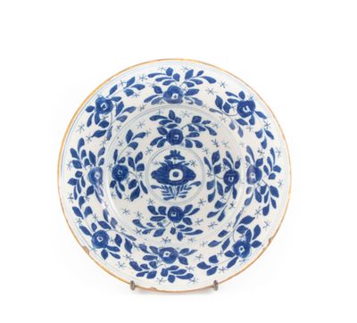 une assiette bleue et blanche décorée de fleurs et de feuilles