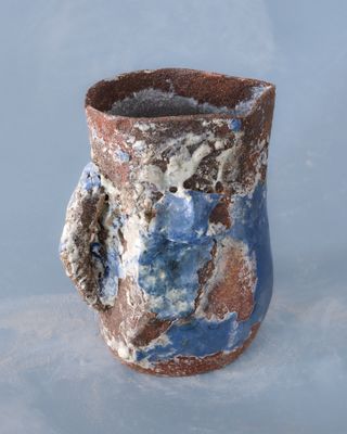 un vase bleu et marron posé sur une table