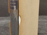 an old book sitting in a cardboard box on top of a table