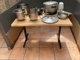 many pots and pans on a table in the kitchen