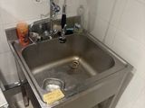 a sink in the corner of a bathroom with a faucet