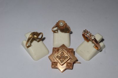 three rings and a ring holder are sitting on a white surface