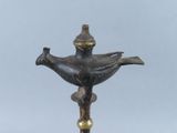 a bronze lamp that has a bird on top of it