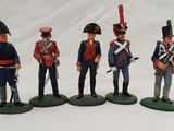 four figurines of men in uniforms of different sizes and colors