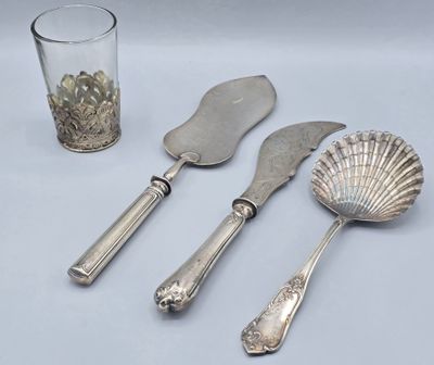 un service d'argenterie posé sur une table à côté d'un verre