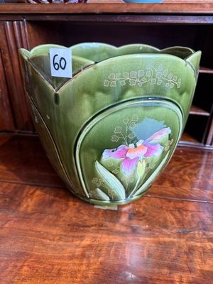 un bol vert orné d'un motif floral, posé sur une table