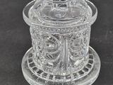 a clear glass bowl with a bird on top of it