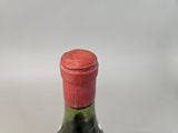 a bottle of wine with a red cap sitting on a table
