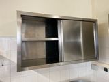 un lavabo en acier inoxydable dans une salle de bains, surmonté d'un miroir