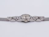 a close up of a watch on a white surface with a chain around it