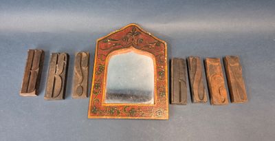 plusieurs morceaux de bois sont disposés autour d'un miroir posé sur une surface bleue