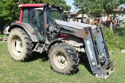 a tractor that is parked on the grass in the yard