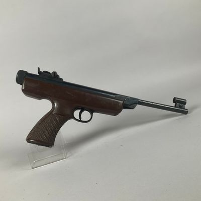 a rifle with a wooden barrel on a clear plastic stand
