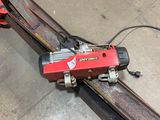 a red machine that is sitting on top of a rail