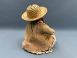 a figurine of a woman wearing a straw hat