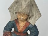 a figurine of a woman with a hat on her head