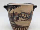 a vase with a picture of a house on it