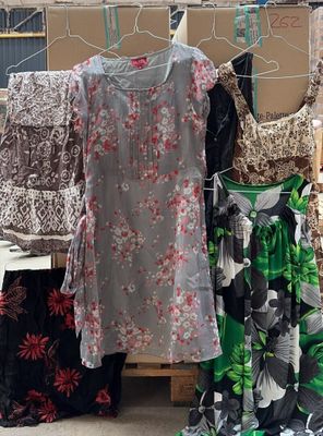 de nombreuses robes suspendues à un portant à l'extérieur