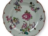 a plate with a floral design on it on a stand