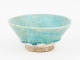 a small blue bowl with a silver rim on a white surface