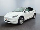 un SUV Tesla blanc garé dans une pièce au sol noir