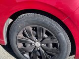 un gros plan d'une voiture rouge avec un pneu crevé