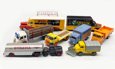 many toy trucks that are lined up together on a white surface