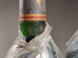two bottles of wine wrapped up in plastic bags