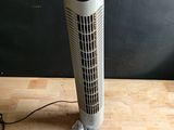 un ventilateur posé sur une table en bois recouverte d'un film plastique