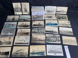 several old postcards of ships and ships on display on a table