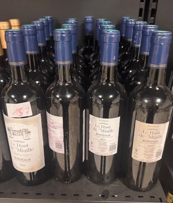 several bottles of wine are lined up on a shelf in a store