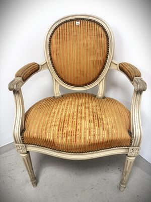 an old chair with a gold upholstered seat and a wooden frame