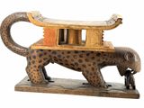 statue of a leopard on a stand with a man standing next to it