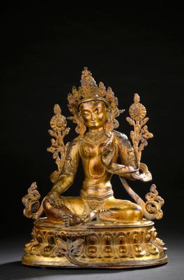 a gold statue of a woman sitting on top of a table