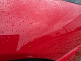 a red car that is parked on the side of the road